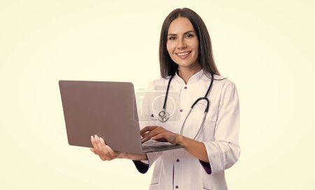 Foto von Krankenschwester halten Laptop für Telemedizin tragen weißen Mantel. Telemedizin von der Krankenschwester. Krankenschwester und Telemedizin isoliert auf weißem Hintergrund. Krankenschwester mit Telemedizinlaptop im Studio.