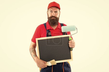 Photo for Puzzled man painter advertising renovation. man painter offer renovation. man painter with blackboard in renovation studio. man painter ready for renovation isolated on white background. - Royalty Free Image
