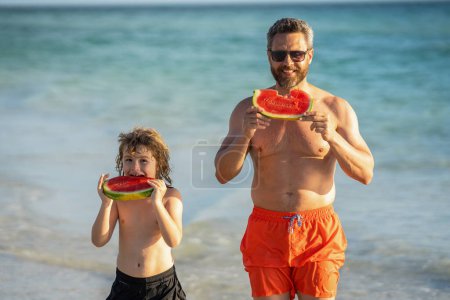 single father with son child at the beach vacation. Loving father dad and son enjoying quality time together at sea. Father and son eating watermelon. dad father and son on summer vacation.