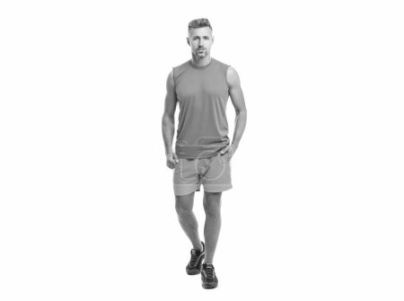 Téléchargez les photos : Un homme athlétique debout au studio de gym. homme athlétique lors d'un cours de yoga. homme athlétique posé avant une compétition de fitness. sportif homme en t-shirt isolé sur fond blanc. - en image libre de droit