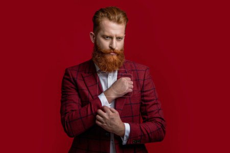 Elegance of bearded gentleman in formal suit. Formalwear. Tux man in formalwear isolated on red. Redhead man in formalwear tuxedo. Man wear elegant formal menswear. Black-tie tuxedo.