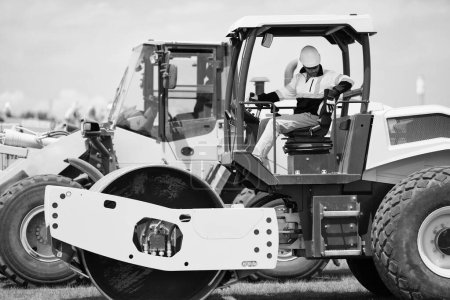trabajador del hombre de la construcción en la construcción maquinaria pesada o equipo de máquina de trabajo en carretera al aire libre.