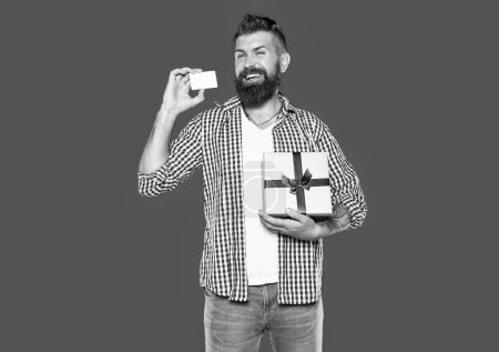 Téléchargez les photos : Homme barbu mature avec boîte enveloppée et carte. concept d'achat en ligne - en image libre de droit