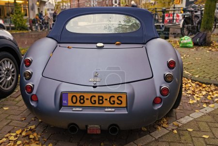 Foto de Ámsterdam, Países Bajos - 15 de noviembre de 2021: Wiesmann GT MF5 roadster vintage convertible classic sport car parking in autumn, back view. - Imagen libre de derechos