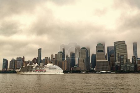 Photo for Cruise ship sailing next Manhattan in New York. Skyline of New York Manhattan cruising on the Hudson River cruise liner . Vacation on cruise liner - Royalty Free Image