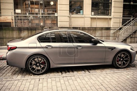 Foto de Ciudad de Nueva York, Estados Unidos - 15 de julio de 2023: BMW F90 M5 coche de color gris estacionado, vista lateral. - Imagen libre de derechos