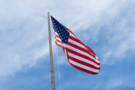 American Flag for Memorial Day or 4th of July. American flag waving in the wind. Flag of the USA. National waving flag of united states on blue sky. Independence day. Patriotic symbol.