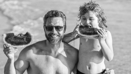 single father with son child childhood at the sea. Loving father dad and son enjoying quality time together at sea. Father and son eating watermelon. dad father and son on summer childhood vacation.