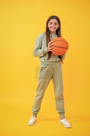 Childhood memories of basketball. teen girl childhood with basketball. teen girl play with ball. basketball in childhood. Learning skills of basketball at teen girl childhood. Skill development.