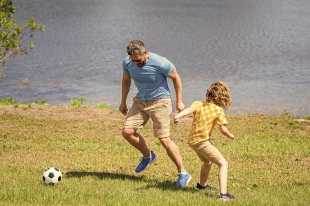 dad and son playing football during their childhood. Childhood memories of son and his dad. dad have fun with son. dad and son enjoying childhood adventures outdoor. journey of fatherhood together.