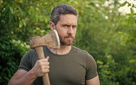 masculine guy with axe outdoor. photo of masculine guy with axe outside. masculine guy with axe. bearded masculine guy with axe.