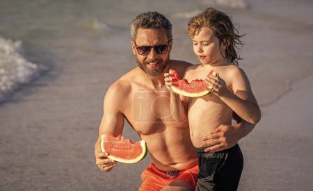 Fathers day. Father dad and son eating watermelon. dad and son on parenthood vacation. single dad father with son at the beach. Loving dad and son enjoying parenthood at sea.
