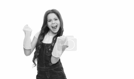 Foto von fröhlichen Putzmädchen mit Handschuhen. Putzmädchen in Putzhandschuhen mit Kopierraum. Teen Girl Putzfrau in Handschuhen isoliert auf weißem Hintergrund. Putzmädchen trägt Handschuhe im Studio.