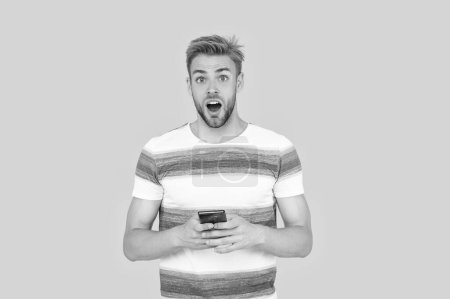 Photo for Shocked man uses his phone to text or message making communication convenient. man uses phone to make effective communication. man has phone communication. digital communication of man with phone. - Royalty Free Image