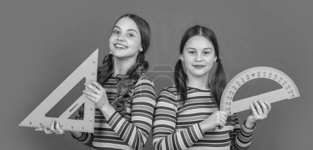 Photo for Smiling school students hold math tool of triangle and protractor. - Royalty Free Image