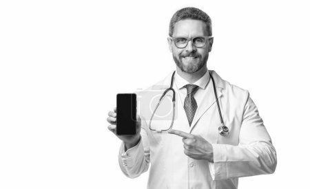l'homme médical pointe du doigt la télésanté en studio. Le médecin montre la télésanté en arrière-plan. photo de l'homme médical montrent la télésanté sur l'écran du téléphone. homme médical montrent la télésanté isolé sur blanc.