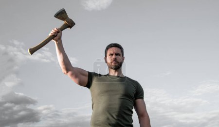 confident man with axe. caucasian man hold ax. brutal man showing strength on sky background.