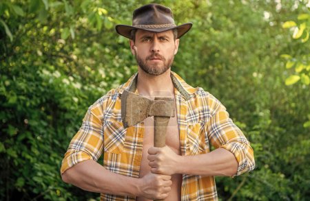 bearded lumberjack with axe wearing checkered shirt. lumberjack with axe outdoor. photo of lumberjack with axe. lumberjack with axe.