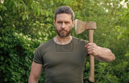 photo of masculine guy with axe or ax. masculine guy with axe. bearded masculine guy with axe. masculine guy with axe outdoor.