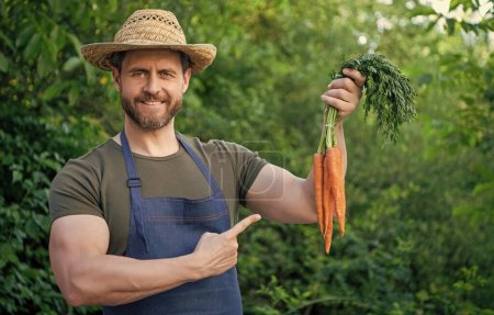 hombre verdulero en paja sombrero de punta dedo en la zanahoria vegetal.