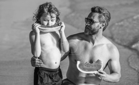 father hugging son kid enjoying parenthood at sea. Father dad and son eating watermelon. dad father and son love and support in parenthood. single father with son at the beach. hapy fathers day.