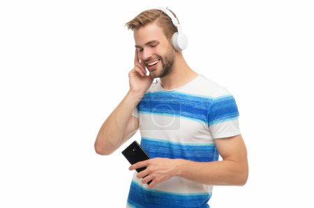 Millennial man listening to music in headphones. Man with headphones using phone. Generation z guy use phone application for training or music. Modern phone with wireless headphones isolated on white.