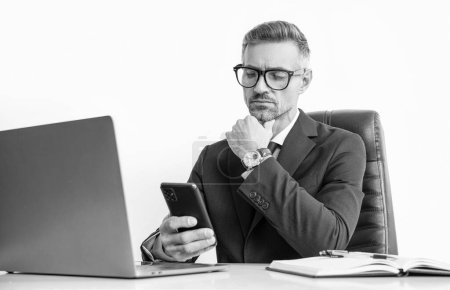busy businessperson in eyewear using phone in office with computer.