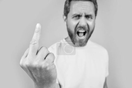 rude middle finger gesture isolated on yellow. rude middle finger gesture on background. rude middle finger gesture in studio. photo with rude middle finger gesture of man.