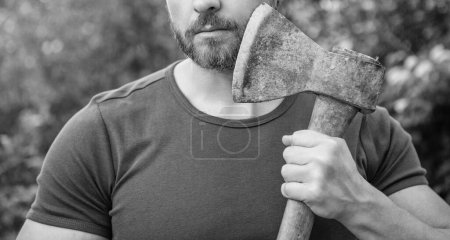 cropped view of bearded masculine guy with axe. masculine guy with axe outdoor. photo of masculine guy with axe. masculine guy with axe.