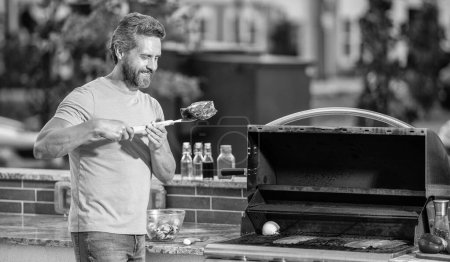 man preparing grilled food at backyard barbecue. man with hot grill at a barbecue party. man grilling delicious barbecue on a summer day. Sizzling hot grill. sirloin steak.