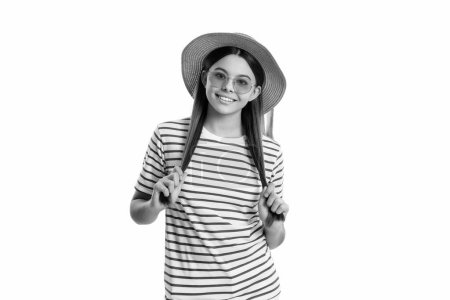 Foto des Sommerurlaubs lächelnde Teenie-Mädchen mit Hut und Streifen-T-Shirt. Sommerurlaub Teenager Mädchen isoliert auf weiß. Sommerurlaub Teenie-Mädchen auf Hintergrund. Sommerurlaub teen girl im studio.
