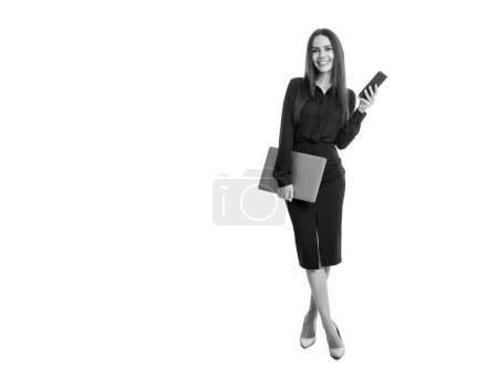Happy businesswoman holding mobile phone and laptop. Businesswoman using mobile and computing devices in business. Business communication. Mobile technology, copy space.