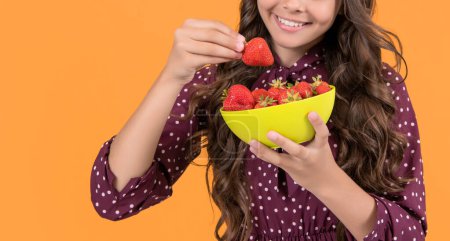 cropped view of teen child smile hold strawberry bowl on yellow background.