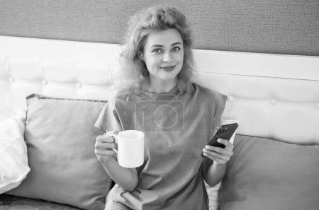 positive woman with coffee chat on phone. woman chat at home with phone. phone chat at home of woman.
