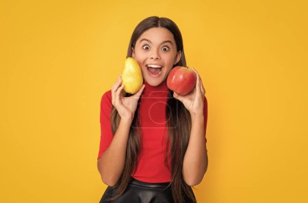 smiling surprised girl hold fresh apple and pear on yellow background.