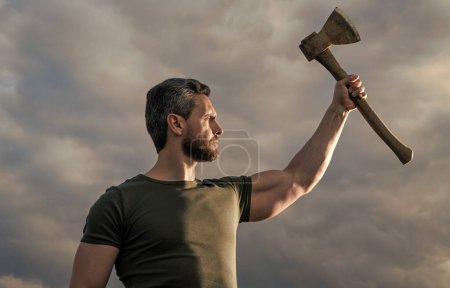 confident man with axe. free caucasian man hold ax. brutal man on sky background.