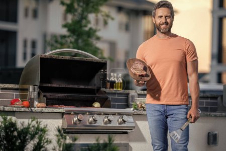 cuisinier présentant ses techniques de barbecue à l'événement cookout. Un homme qui aime faire un barbecue. homme griller ses viandes préférées, copier l'espace. Délices grillés appétissants. agneau rôti.