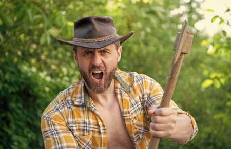 Bild eines wütenden Holzfällers mit Axt. Wütender Holzfäller mit Axt. Wütender Holzfäller mit Axt im karierten Hemd. Wütender Holzfäller mit Axt im Freien.