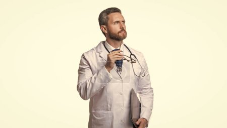 photo of thoughtful emedicine and doctor man with laptop. doctor promoting emedicine isolated on white. doctor offering emedicine in studio. doctor presenting emedicine on background.