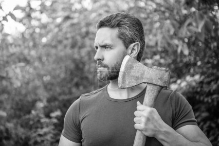 caucasian bearded masculine guy with axe. masculine guy with axe outdoor. photo of masculine guy with axe. masculine guy with axe.