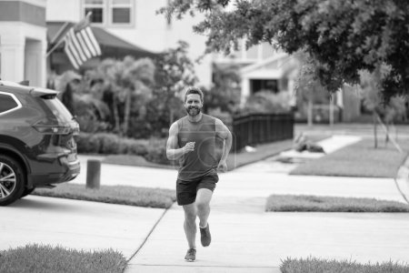 energetic running man races down neighbourhood. running man enjoys the freedom of running outdoor. running man feels sense of joy during the run. sport fit man jogging outdoor. active lifestyle.