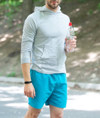 Healthy lifestyle. Water balance in body. Drinking per day. Hydration vitality. Be hydrated. Thirsty sportsman. Man hold mineral water. Feel thirsty. Young man with sport plastic bottle. Cropped view.