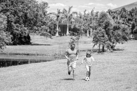 Outdoor adventures of daddy and son fatherhood together. football family team of father and son. happy childhood. Fatherhood in outdoor of daddy and son kid. daddy with son improve fatherhood.
