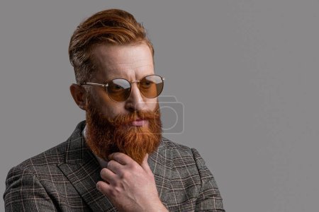 Elegance of bearded man in formal suit. Tuxedo man in menswear isolated on grey. Redhead man in menswear tuxedo. Man wear elegant formal menswear. Copy space. Regal elegance.