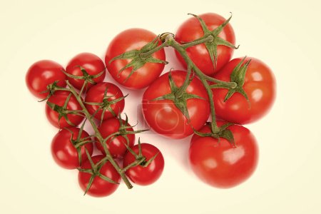 Organic red cherry tomato clusters of different size isolated on white.