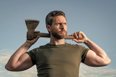 confident man with axe. woodcutter man hold ax. brutal man on sky background.
