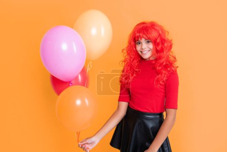 child smile with party balloon on yellow background.