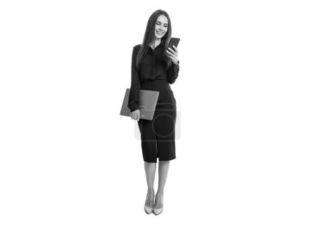 Businesswoman using mobile technology in business. Businesswoman communicating with customers through text messages. Businesswoman holding mobile phone and laptop. Business communication.