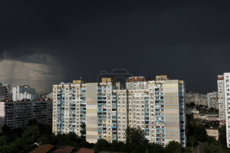 Foto de Nubes de lluvia negra en el cielo sobre edificios residenciales de gran altura. Clima tormentoso en la ciudad. Lluvia y nubes oscuras. mal tiempo Cielo aterrador. - Imagen libre de derechos