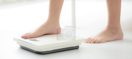 Foto de Primer plano del pie de la mujer de pie en balanzas que miden el peso del control en la habitación, el sobrepeso y la dieta, la salud y la pérdida de peso, examinando la grasa con pesaje, interior, conceptos saludables. - Imagen libre de derechos